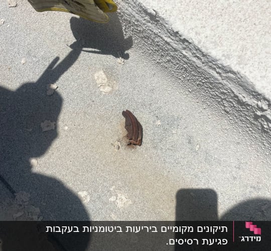 כפפות עבודה ליד קיר בטון עם סדק